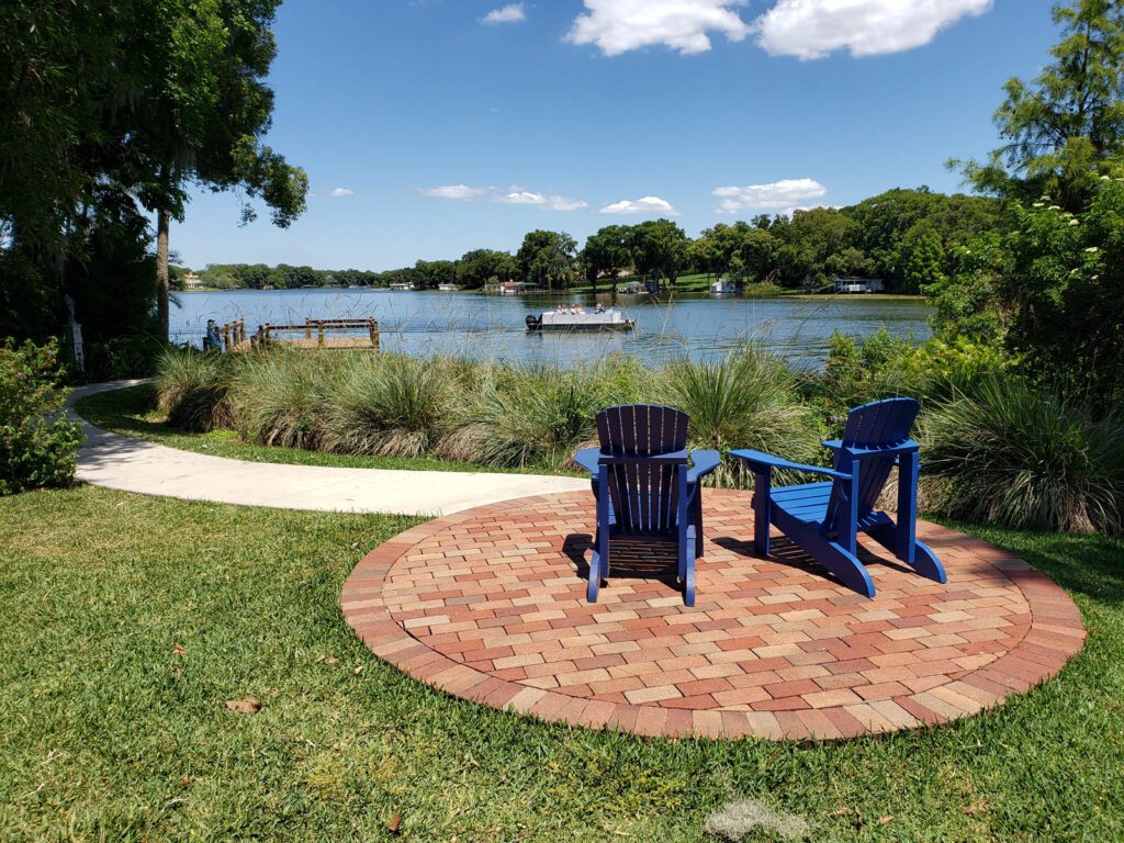 Lakefront lawn with two blue chairs and a view across the water